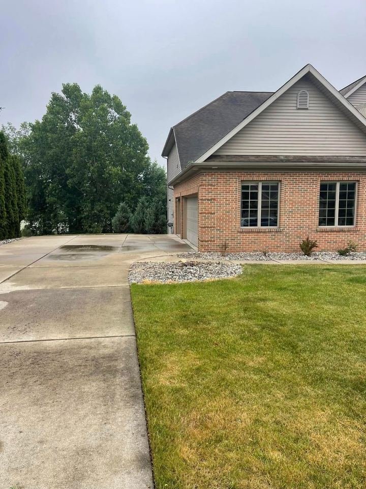 Same house after tree removal, driveway and beds cleared